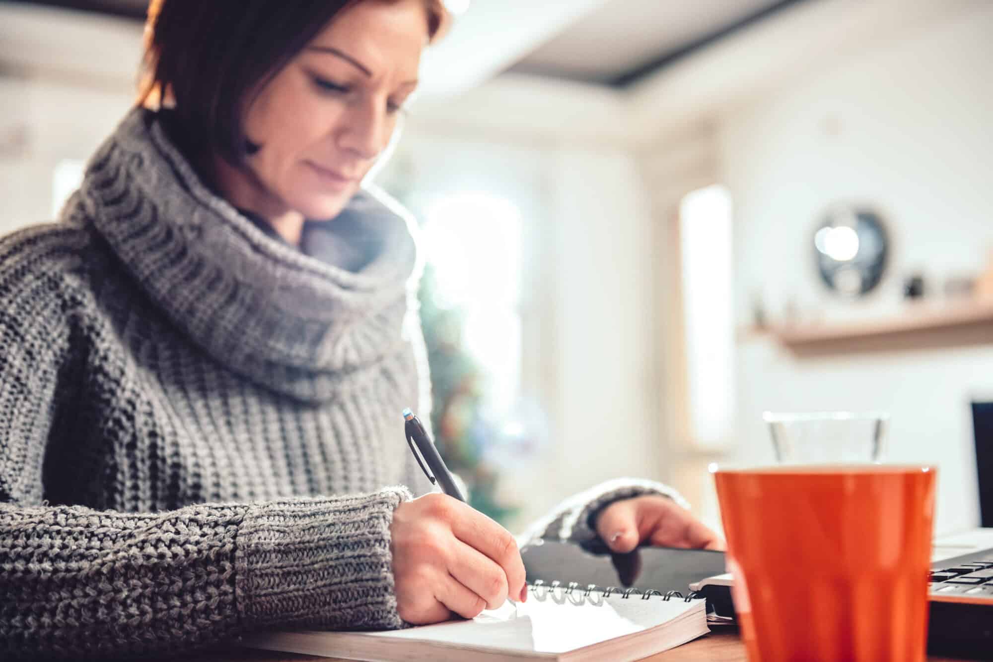 Woman writing down notes in her notebook